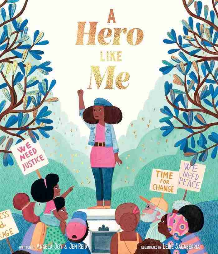 Illustrated book cover depicting a woman with a raised fist on a podium, surrounded by people holding protest signs. Text reads "A Hero Like Me," capturing the spirit of empowerment often found in books about mothers.